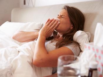 Frau liegt mit Grippe im Bett 