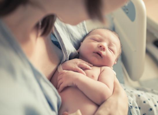 Nestschutz: Foto einer Mutter, die ein neugeborenes Baby im Armhält